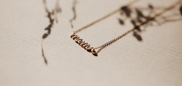 the story behind the mama script necklace