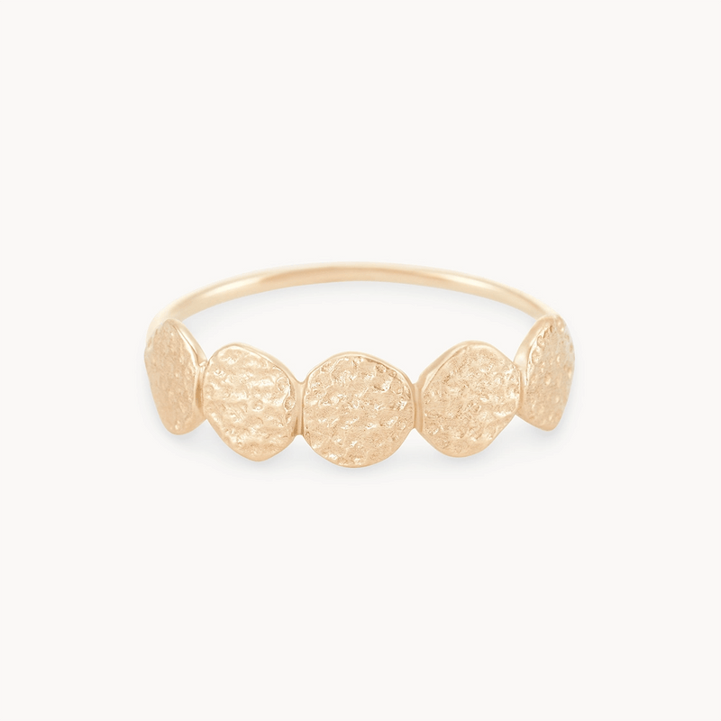 A delicate abacus disk ring - 14k yellow gold with a textured design featuring five small, irregularly shaped discs evenly spaced along the band. The background is white, highlighting the intricate detail of the ring.