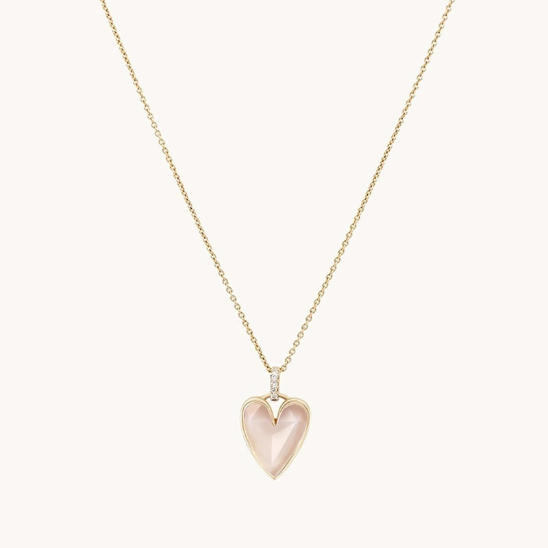 This elegant and refined "pink opal diamond heart mood charm" by bluboho features a delicate 10k yellow gold necklace adorned with a heart-shaped pendant. The pendant showcases a soft pink opal gemstone set in gold, accented with diamonds, beautifully contrasting against a plain white background.