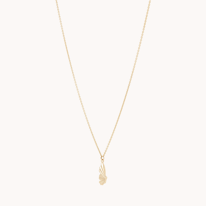 The bluboho metamorphosis butterfly wing necklace in 14k yellow gold features a delicate thin chain and a pendant shaped like an abstract, elongated wing. The simple white background accentuates the piece's elegance and sophistication.