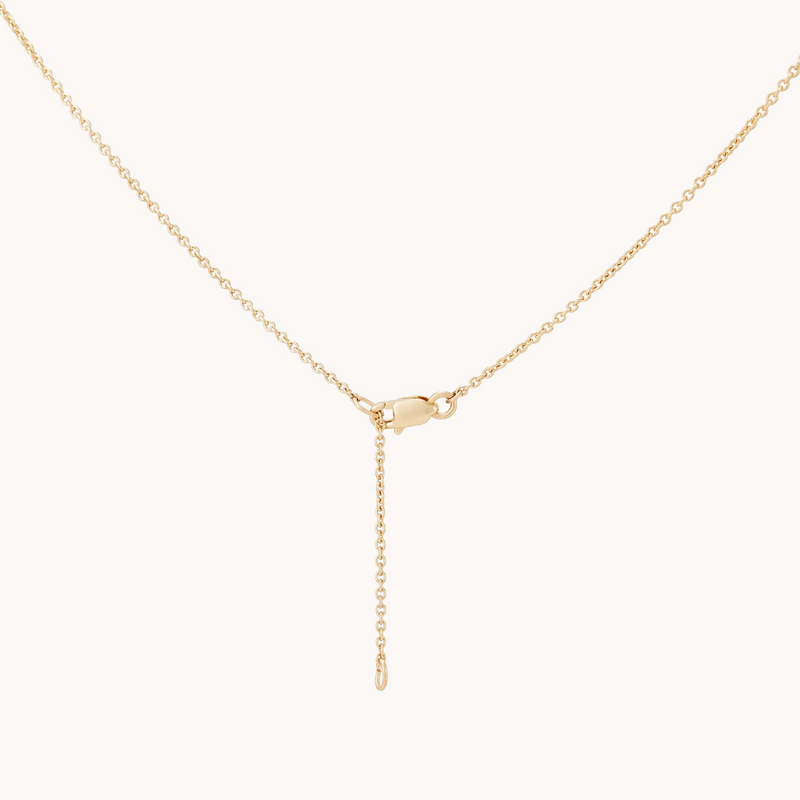 The delicate Metamorphosis Butterfly Wing Necklace by bluboho, crafted from 14k yellow gold, features a lobster clasp in the middle. One end of the chain threads through the clasp, creating an adjustable length with a dangling chain segment. Set against a white background, its simplicity and elegance are beautifully highlighted.