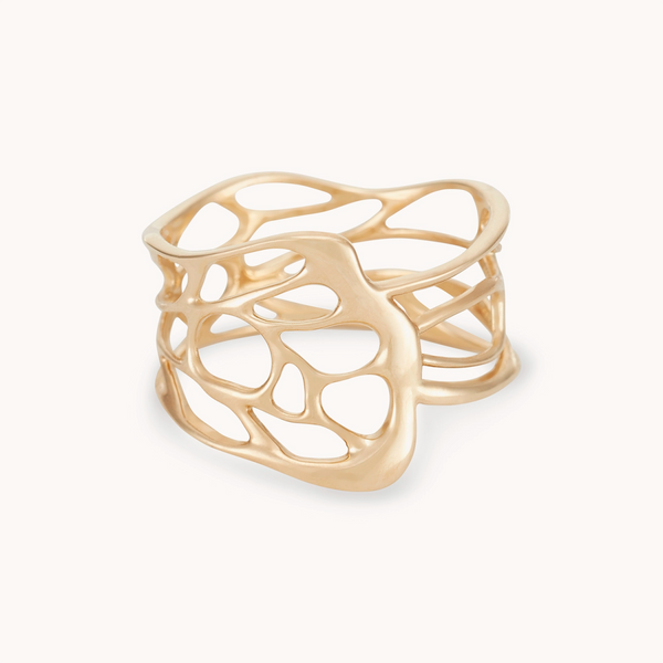 The "winged being butterfly ring" by bluboho is a 14k yellow gold masterpiece featuring a modern, intricate design. The band showcases an openwork pattern that resembles abstract, flowing organic shapes, lending it a lightweight and delicate appeal. The ring is completed with a smooth, polished finish.