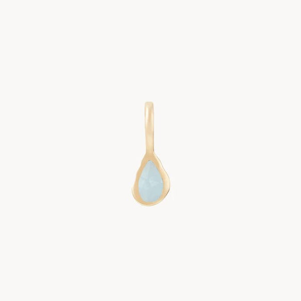 A delicate pendant featuring a teardrop-shaped light blue gemstone set in a smooth, gold-toned frame. The pear aquamarine march mood birthstone charm - 10k yellow gold, aquamarine by bluboho has a simple gold loop at the top for attaching to a chain. The background is plain white, emphasizing the elegance of the pendant.