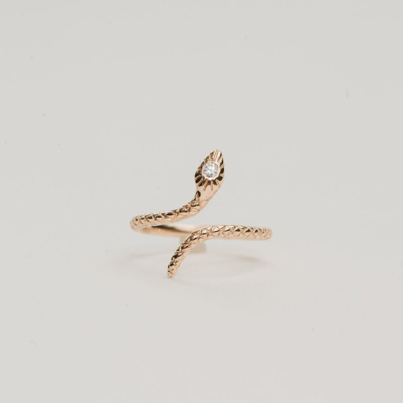 Introducing the Serpent Revival Diamond Cuff Ring by bluboho, crafted in 14k yellow gold with intricately textured scales. This exquisite ring is designed in the shape of a coiled snake and features a sparkling diamond on the snake's head, showcased beautifully against a plain light gray background.