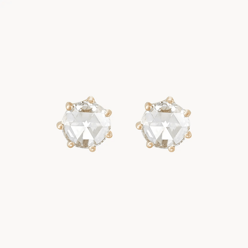 A pair of **large supernova earrings** by **bluboho** featuring faceted, round-cut clear gemstones set in gold-tone prongs, displayed against a plain, light background.