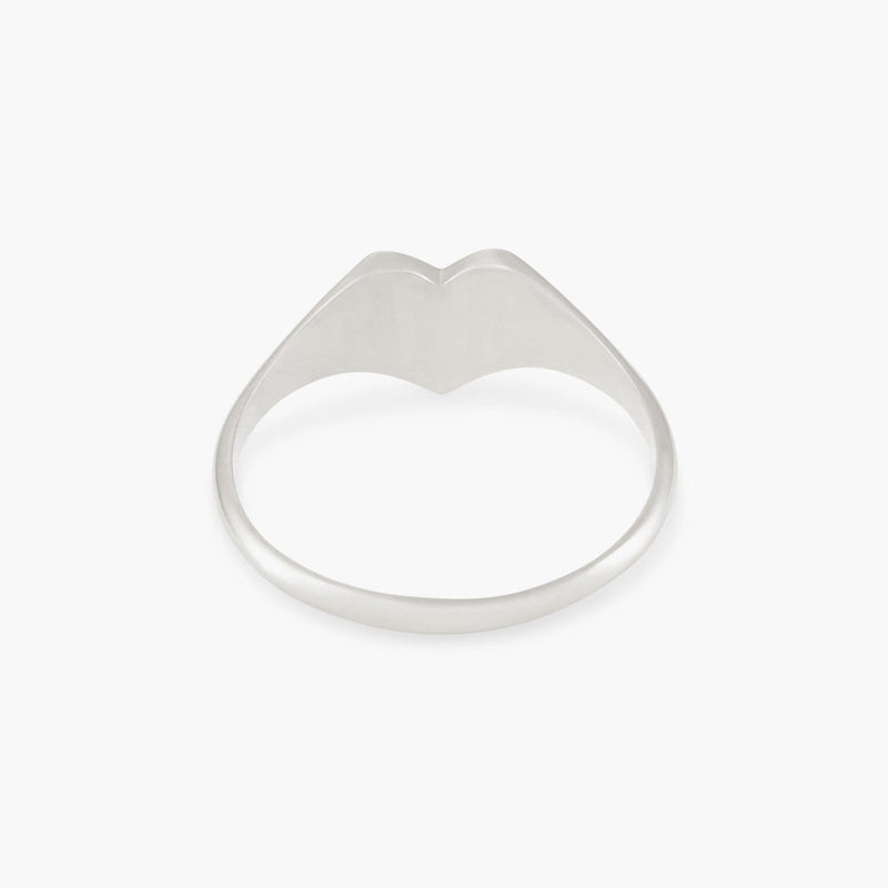 The lovely heart signet ring by bluboho features a sleek, minimalist design in sterling silver. At the crown, a small, subtle V-shaped curve adds to its modern and stylish appearance. The polished surface softly reflects light, enhancing its elegant simplicity against the plain white background.