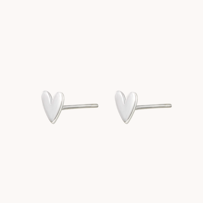 A pair of simple, elegant, heart-shaped stud earrings made of smooth sterling silver. The lovely heart earring silver by bluboho is displayed against a plain white background, highlighting its minimalistic design.