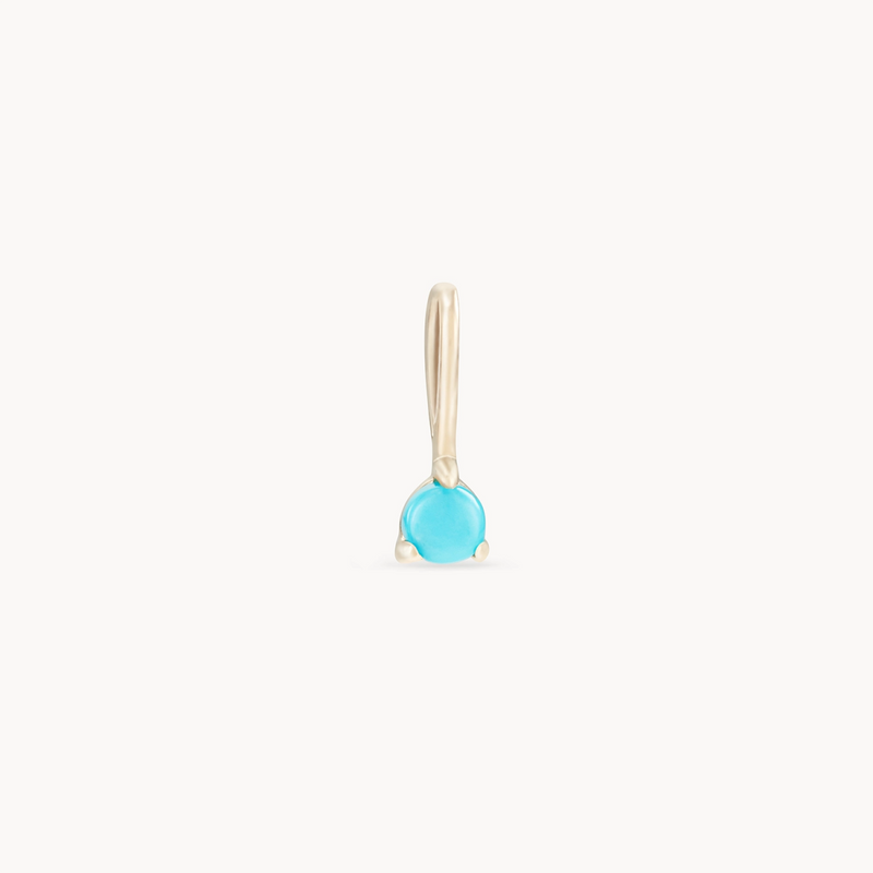 Introducing the serendipity December birthstone charm by bluboho—a 10k yellow gold charm featuring a small, circular turquoise gemstone. The gem is set in a simple yet elegant design that beautifully showcases its vibrant blue color. This pendant includes a sleek gold bail for easy attachment to any necklace.