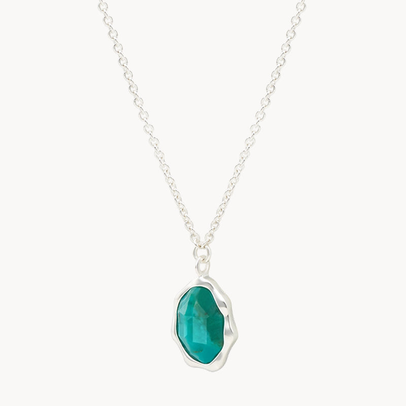 A turquoise mood necklace silver - sterling silver, turquoise from bluboho features a pendant set with an oval-shaped, faceted teal gemstone. The gem is encased in an irregular, organic-shaped silver setting, adding a unique touch to the elegant design.