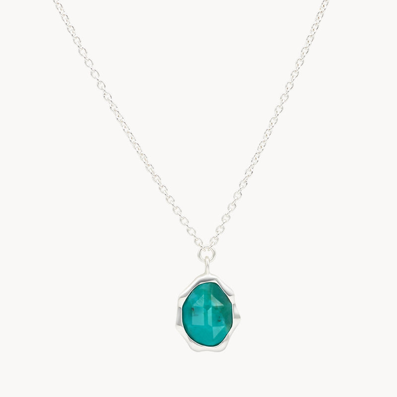 A delicate bluboho turquoise mood necklace silver - sterling silver, turquoise with a pendant featuring a faceted, vibrant teal gemstone encased in a unique, modern silver setting. The pendant hangs centrally from the chain, showcasing the elegant design and the striking color of the gemstone.