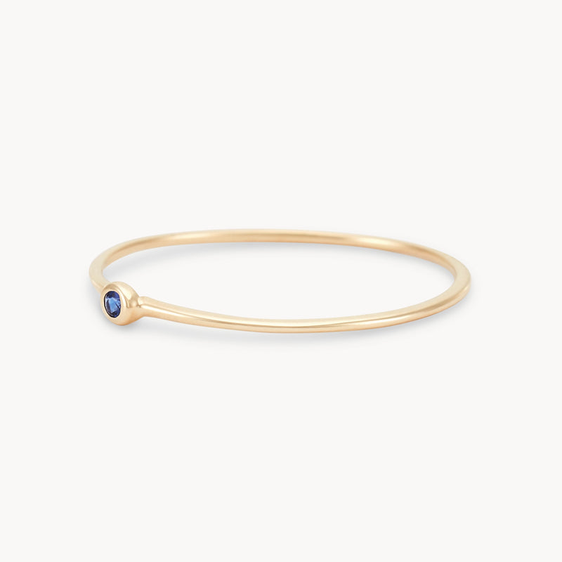 new bezel set serendipity blue sapphire  stacking ring - 10k yellow gold angled view