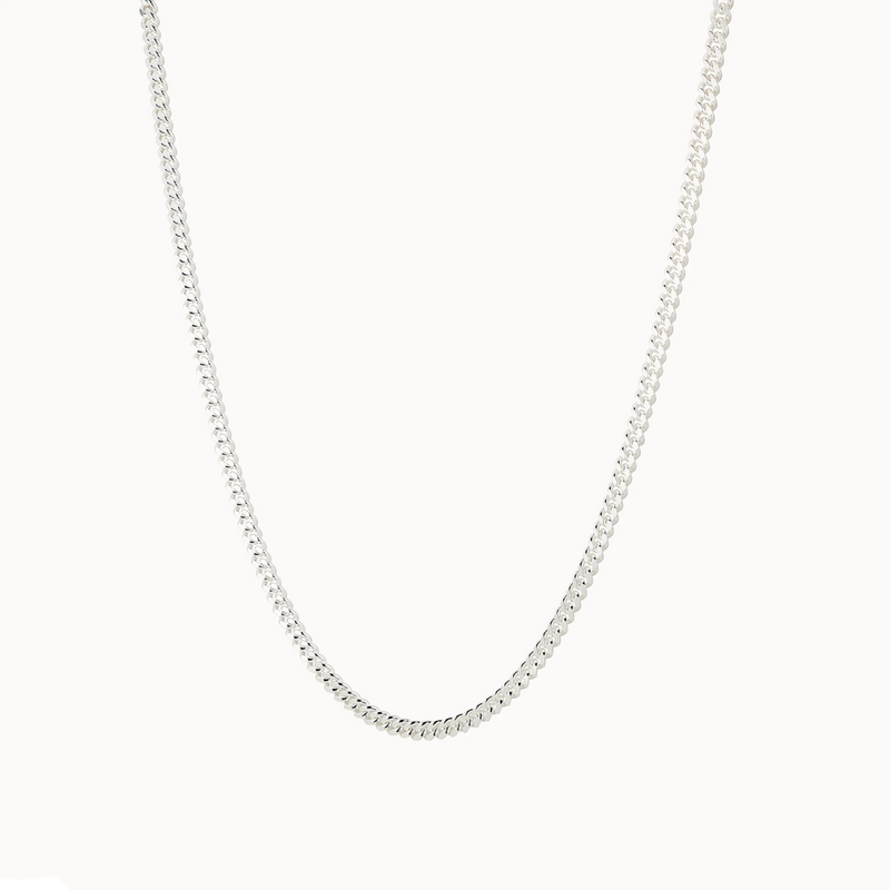 Introducing the curb silver necklace - sterling silver by bluboho, a simple and elegant piece featuring small, closely linked oval-shaped links forming a smooth, continuous loop. The necklace is beautifully displayed against a plain white background.