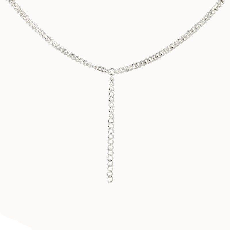 The curb silver necklace - sterling silver by bluboho is a delicate piece that boasts an extended drop-down chain segment in the center. The design is simple and elegant, featuring a fine, interlocking link pattern.
