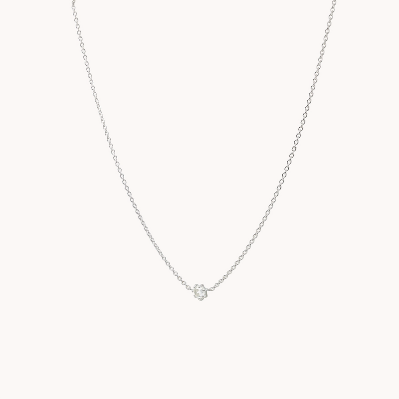 Introducing the supernova white sapphire necklace in sterling silver by bluboho— a delicate and elegant accessory. This beautifully crafted silver chain showcases a small, single white sapphire pendant at its center. The simple design highlights the sparkling gem, adding a subtle yet sophisticated touch to any look against a plain, light-colored background.