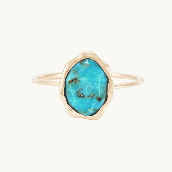 The bluboho turquoise mood ring in 14k yellow gold showcases an irregularly shaped, bezel-set turquoise stone adorned with natural brown and black veining. The thin band highlights the vibrant blue stone, resulting in an elegant and minimalist design.