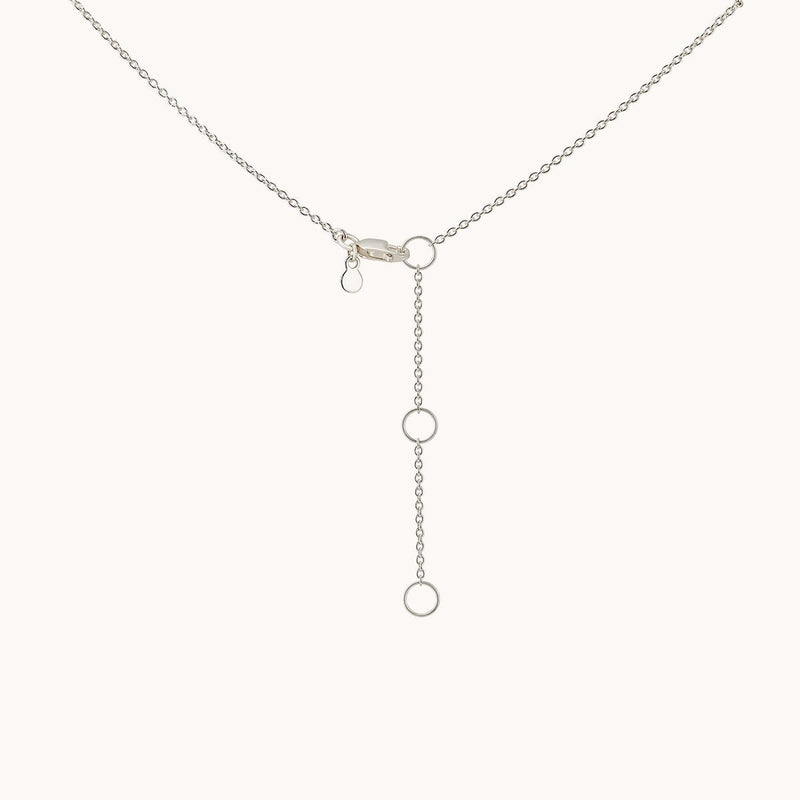 Introducing the *stella star necklace silver - sterling silver* by *bluboho*: This elegant silver necklace showcases a stunning drop design with three vertically arranged circular links at the center. It features a fine chain and is secured with a small clasp at the top, all set against a plain white background.