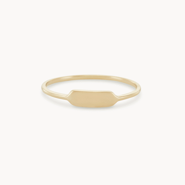 A thin, plain gold ring with a slightly flattened, rectangular segment at the front center, against a white background. The design is minimalist and elegant. Product: Namesake ring - 14k yellow gold, engravable by bluboho.