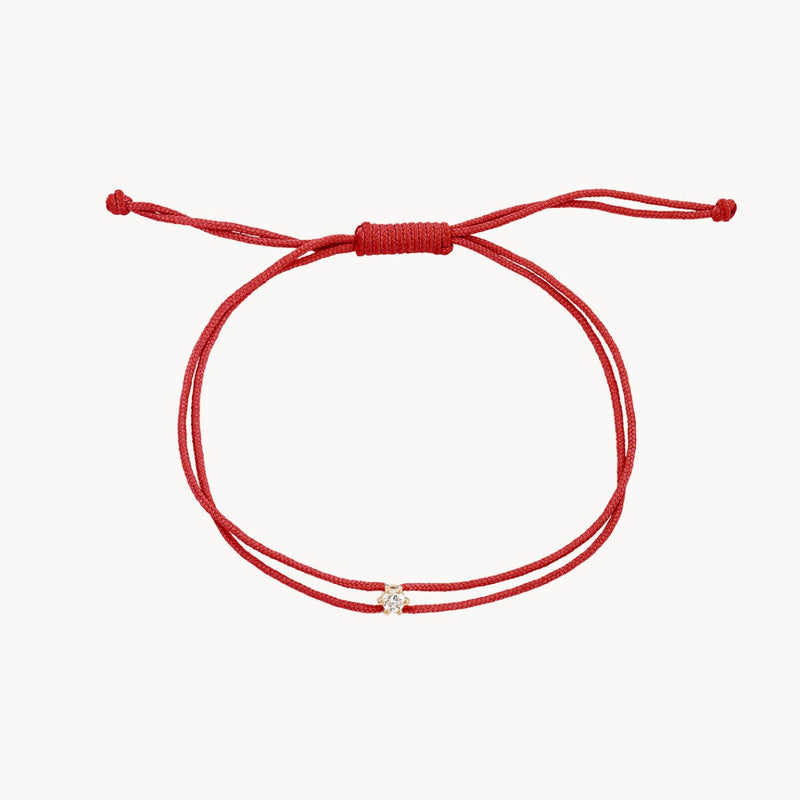 The nova diamond red cord bracelet by bluboho features an elegant, finely woven red nylon string with an adjustable knot closure. At its center, a small diamond set in 10k yellow gold adds a touch of refined sophistication to this minimalist accessory.