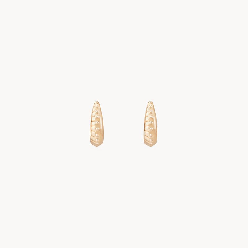 A pair of delicate "restoration mini hoop - 14k yellow gold" earrings by bluboho displayed against a plain white background. The earrings have a slightly oblong shape, with a textured pattern of small dots along their surface. They are simple, elegant, and minimalistic in design.