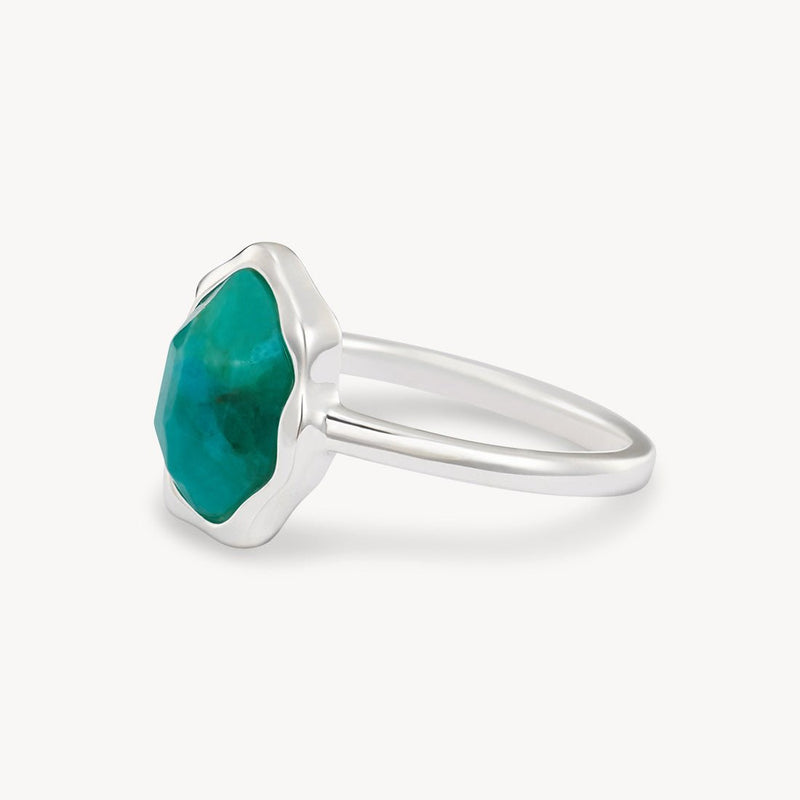 A turquoise mood ring featuring a large, multi-faceted green gemstone in a prong setting by bluboho. The sterling silver gemstone has an irregular, organic shape, adding a unique touch to the minimalist band. The ring is displayed against a plain white background.